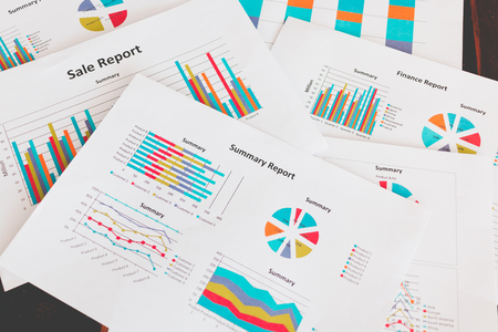 Financial graphs and charts on wooden tableの写真素材