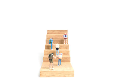 Miniature people: Backpacker standing on wood block isolated on white background, Travel conceptの写真素材