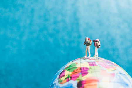 Miniature Backpacker , Travelers with backpack standing on world map and walking to destinationの写真素材
