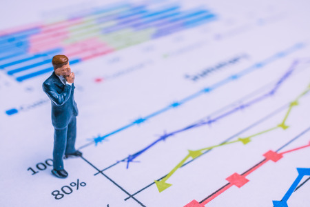 Miniature People : Businessman standing on a Paper graph chart ,Developing a teamwork concept
