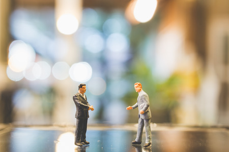 Miniature people , Businessman standing on glass with blurred backgroundの写真素材