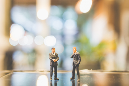 Miniature people , Businessman standing on glass with blurred backgroundの写真素材
