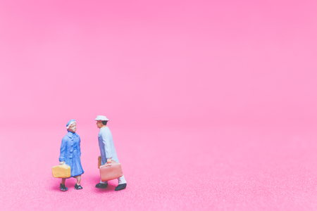 Miniature people : Couple of travellers on pink backgroundÂ , Valentine's day conceptの写真素材