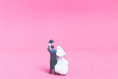 Miniature people wedding , Bride and groom on pink background , Valentine's day conceptの写真素材