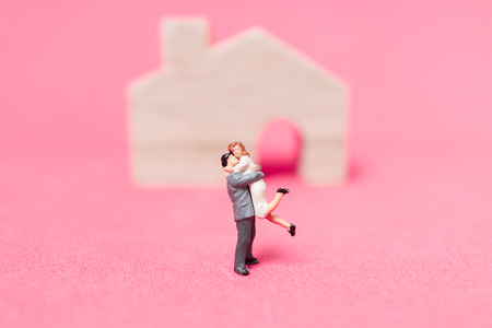 Miniature people : Couple with house on pink background , Valentine's day conceptの写真素材