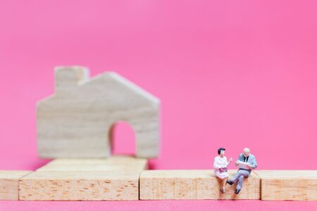 Miniature people : Couple with house on pink background , Valentine's day conceptの写真素材