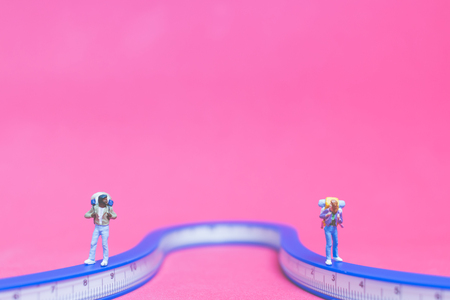 Miniature people : Couple of travellers on The bridge on pink background , Valentine's day conceptの写真素材