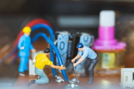 Miniature people : Worker team repairing Electronic Circuits. , Construction workers conceptの写真素材
