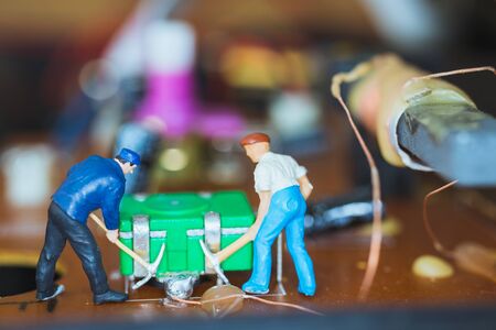 Miniature people : Worker team repairing Electronic Circuits. , Construction workers concept