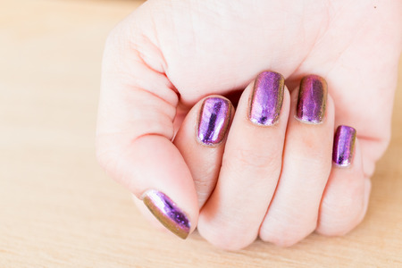 Beautiful nail polish in hand, Purple nail art manicure, Woman's handの写真素材
