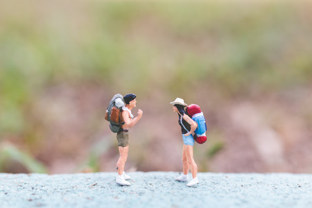 Miniature people :  Traveler with backpack standing on The road . Travel and trekking Conceptの写真素材