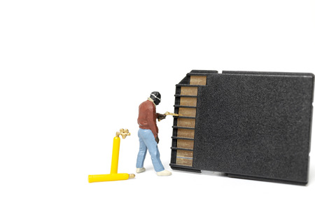 Miniature people technician fixing pile of sd cards on white background with copy space.の写真素材