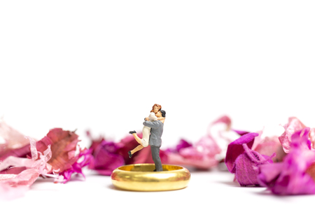 Miniature people : Couple hug in The pink garden with a wedding ring isolate on white backgroundの写真素材