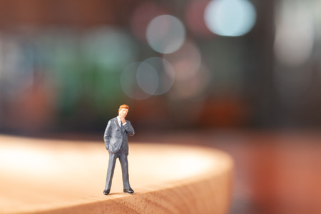 Miniature people : Businessman  standing and thinking with colorfull backgroundの写真素材