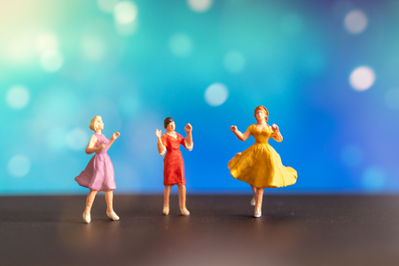 Miniature people , Woman in colored dress  dancing against bokeh backgroundの写真素材