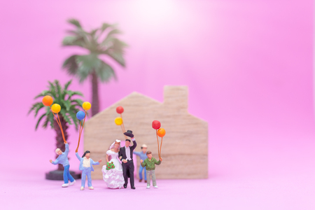 Miniature people, Couple and family with colorful balloons celebrating on pink backgroundの写真素材