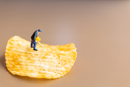 Miniature people : Worker are working with potato chipsの写真素材