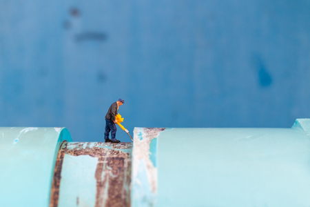Miniature people, Working Plumbers install water pipes and check damage to water pump machines