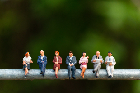 Miniature people : business people sitting on a  wire with green background 
, Business  team conceptsの写真素材