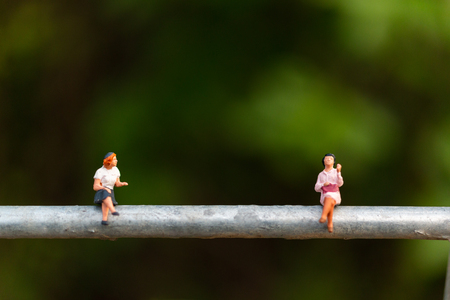 Miniature people : business people sitting on a  wire with green background 
, Business  team conceptsの写真素材