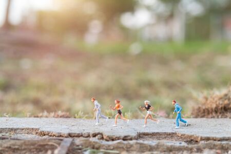 Miniature people : Running on the road with nature background , Health And lifestyle concepts