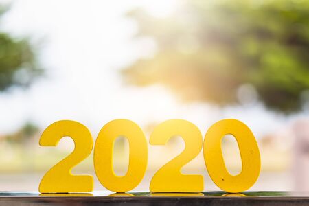 Wooden handmade 2020 numbers on table with blurred tree backgroundの写真素材