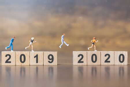 Miniature people Jump from number 2019 to number 2020 , Happy new year concepts.