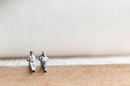 Miniature people: Businessman reading book on  old book  , Education or business concept.の写真素材