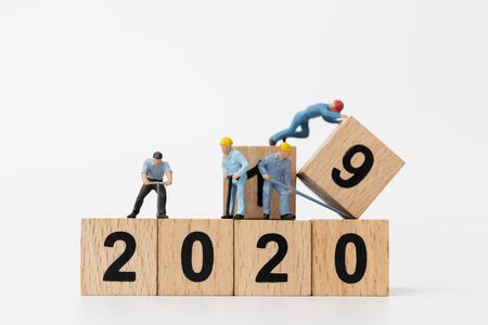 Miniature people : Worker team create wooden block number 2020  , Happy new year conceptの写真素材
