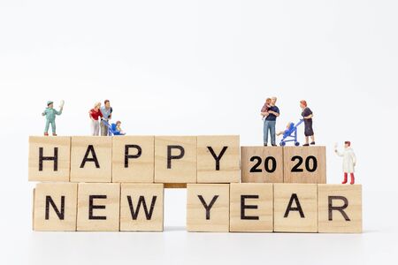 Miniature people : Happy family standing on wooden block  Happy new year concept