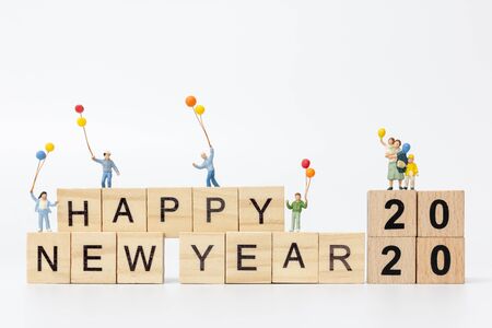 Miniature people : Happy family standing on wooden block  Happy new year conceptの写真素材