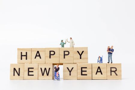 Miniature people : Happy family standing on wooden block  Happy new year conceptの写真素材
