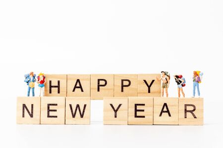 Miniature people : Group of backpacker standing on wooden block  Happy new year conceptの写真素材