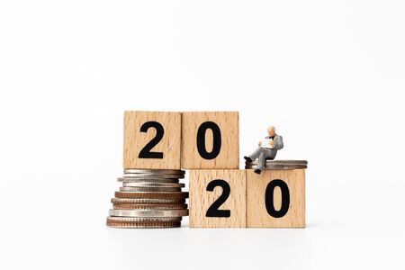 Miniature people : Business people sitting on wooden block number 2020  , Happy new year conceptの写真素材