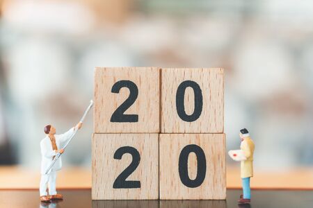 Miniature worker team painted on wooden block number 2020  , Happy new year concept