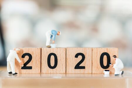Miniature worker team painted on wooden block number 2020  , Happy new year concept