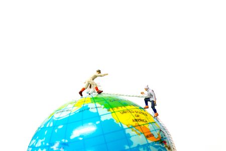 Miniature people: Hikers climbing up on the Globe. Sport and leisure concept.の写真素材