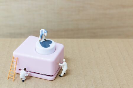 Miniature people painting Heart shaped punching machine with copy spaces for your text , Valentine...