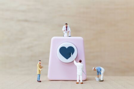 Miniature people painting Heart shaped punching machine with copy spaces for your text , Valentine day concept.の写真素材