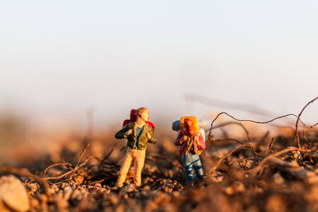 Miniature people : Traveler with backpack mountaineering. Hiking man with backpack walking outdoorの写真素材