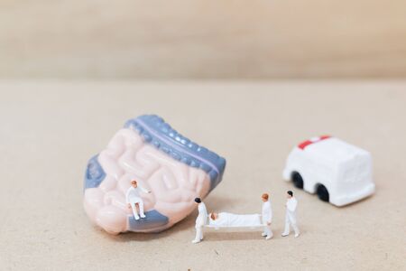Miniature people ; doctor and nurse team specialists observing and discussing about human Intestine...