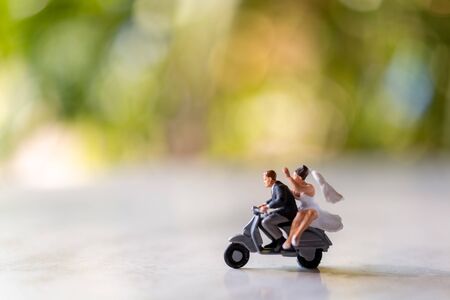 Miniature people : Bride and groom outdoors with green bokeh background and  copy space for text , Happy valentine's day conceptの写真素材