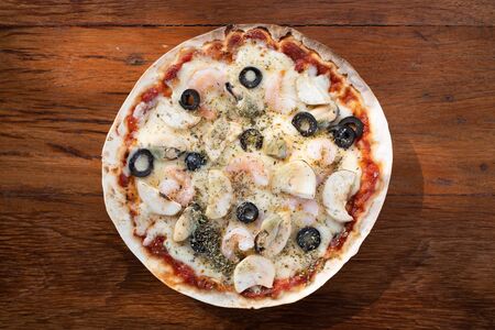 Top view of Homemade Seafood pizza on wooden backgroundの写真素材