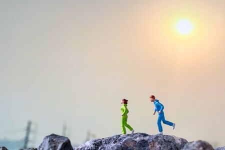 Miniature people : Running on rock cliff with nature background , Health And lifestyle conceptsの写真素材
