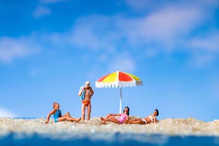 Miniature people sunbathing on The beach , Summer time conceptの写真素材