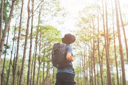 Asian man with backpack hiking in forest , Adventure Travel Remote Relax Concept