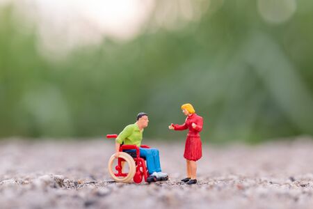 Miniature people : Disabled man sitting in wheelchair in The park and copy space for textの写真素材