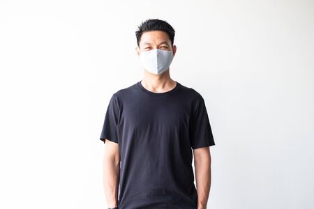 Portrait of Young asian man with homemade fabric mask  standing on white wall backgroundの写真素材
