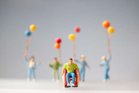 Miniature people Positive family taking care of their disabled Fatherの写真素材