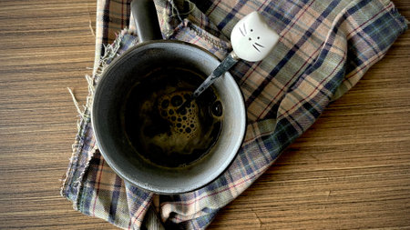 Cup of tea on wooden table with checkered tableclothの写真素材